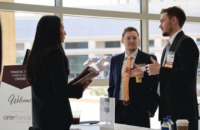 Joe Meylor CFP®, CPWA®, and Cullen Ferguson CFP® visit with a Texas A&M University student during the Career Fair at the Texas A&M University Financial Planning Career & Education Conference, discussing career opportunities and insights into the financial industry